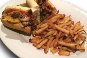 cheese steak sandwich and fries on a plate