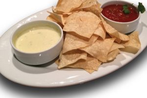 Queso chips and cheese on a plate